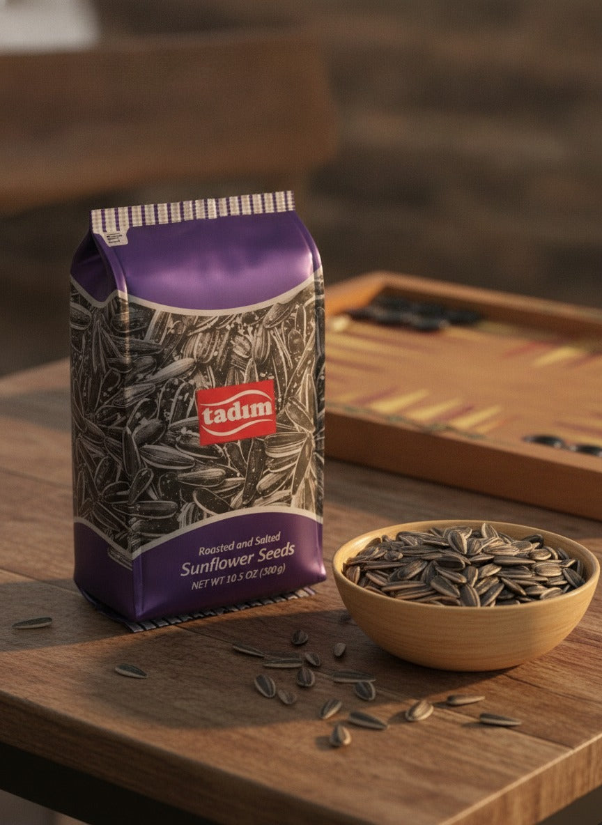 Tadim sunflower seeds beside a bowl of seeds and a backgammon board